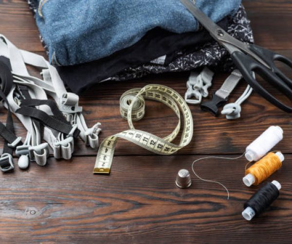 Sewing supplies and materials. Sewing workshop. Clothes and threads on the table. View from above.